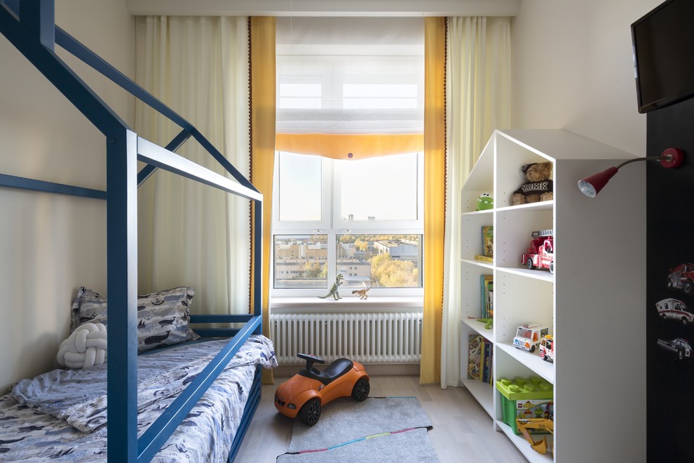 Ispirazione per una piccola cameretta per bambini da 1 a 3 anni contemporanea con pareti beige, parquet chiaro e pavimento beige