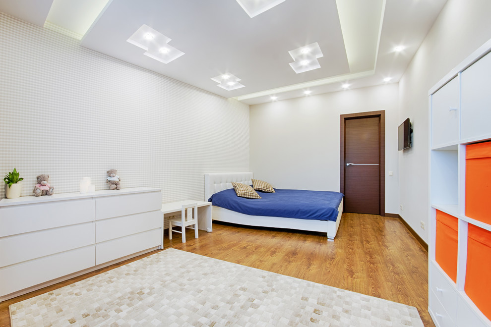 Medium sized contemporary children’s room for boys in Moscow with white walls, laminate floors and brown floors.