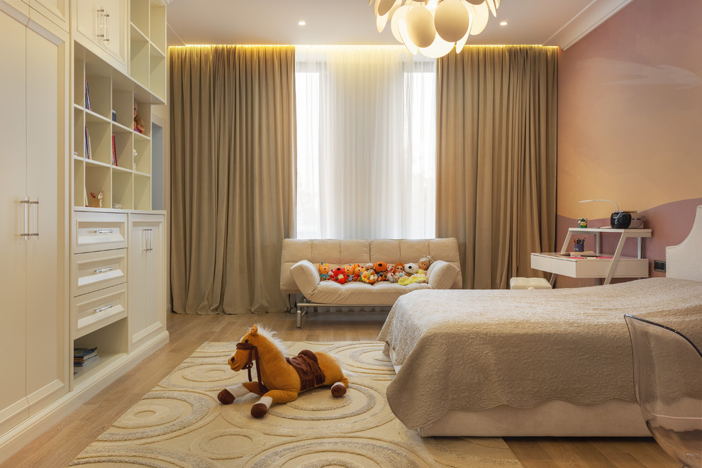 Esempio di una cameretta per bambini da 4 a 10 anni scandinava di medie dimensioni con pareti beige e pavimento in legno massello medio