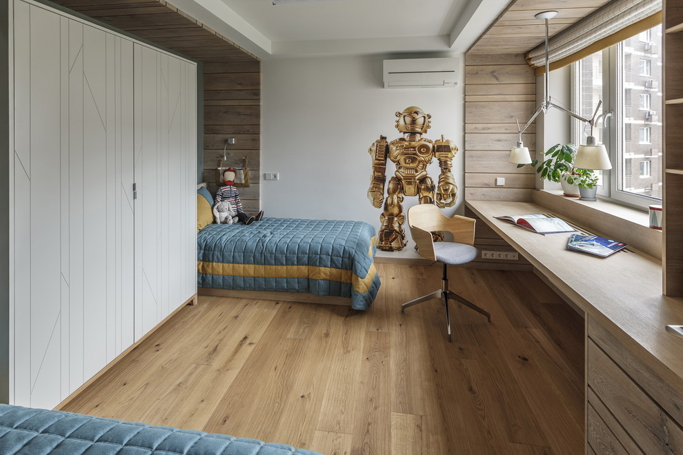 Inspiration for a contemporary kids' study space for boys in Moscow with white walls, light hardwood flooring, beige floors and feature lighting.