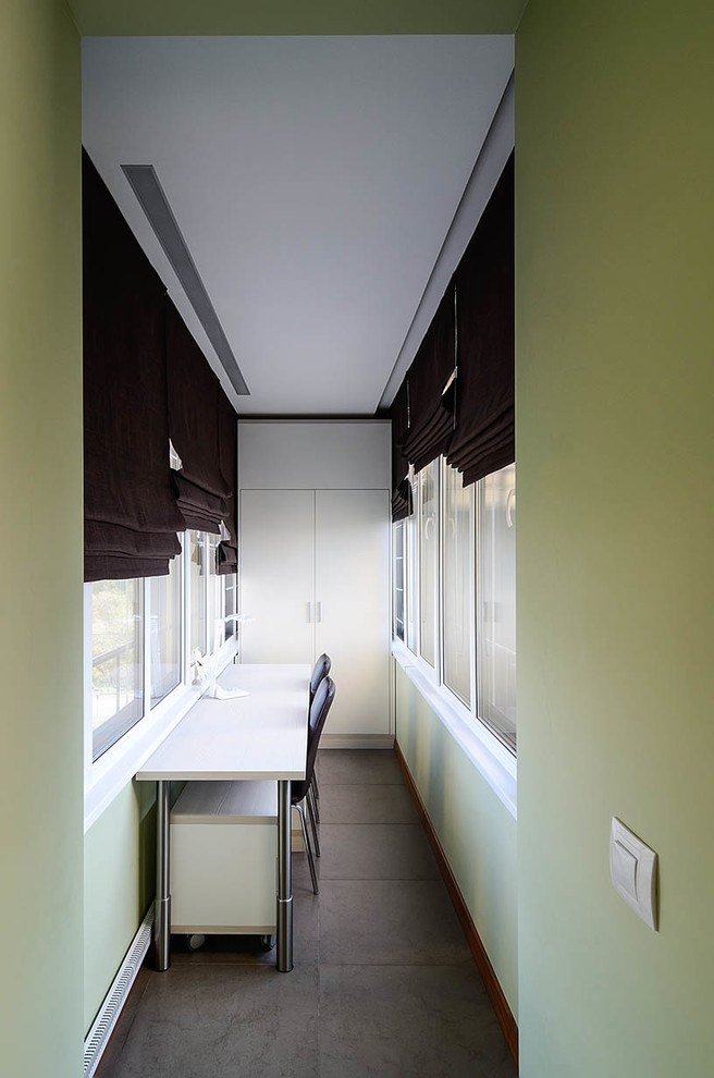 Exemple d'une chambre de garçon de 4 à 10 ans tendance de taille moyenne avec un bureau, un mur vert, un sol en carrelage de porcelaine et un sol marron.