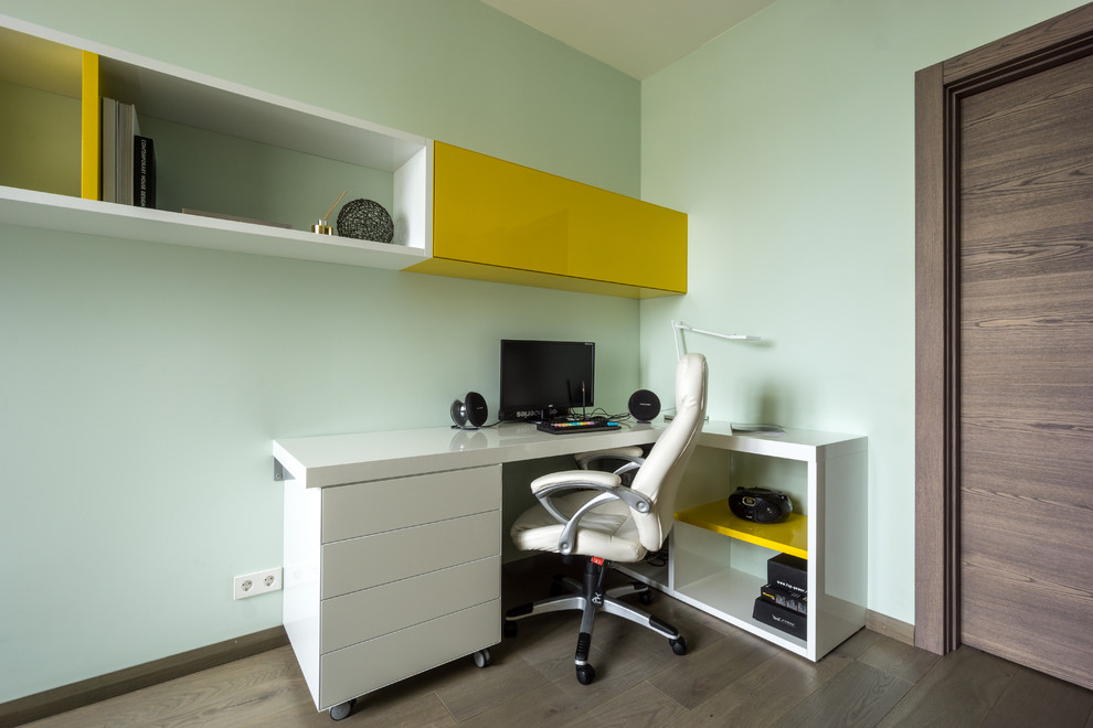 Inspiration pour une chambre d'enfant design de taille moyenne avec un bureau, un mur vert, un sol en bois brun et un sol marron.