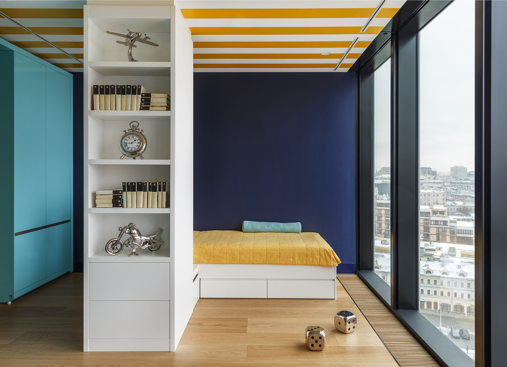 На фото: детская в современном стиле с спальным местом, синими стенами, светлым паркетным полом и бежевым полом для мальчика, подростка с