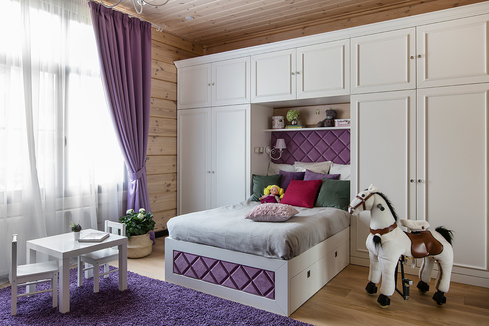 This is an example of a traditional children’s room for girls in Moscow with beige walls, medium hardwood flooring and brown floors.