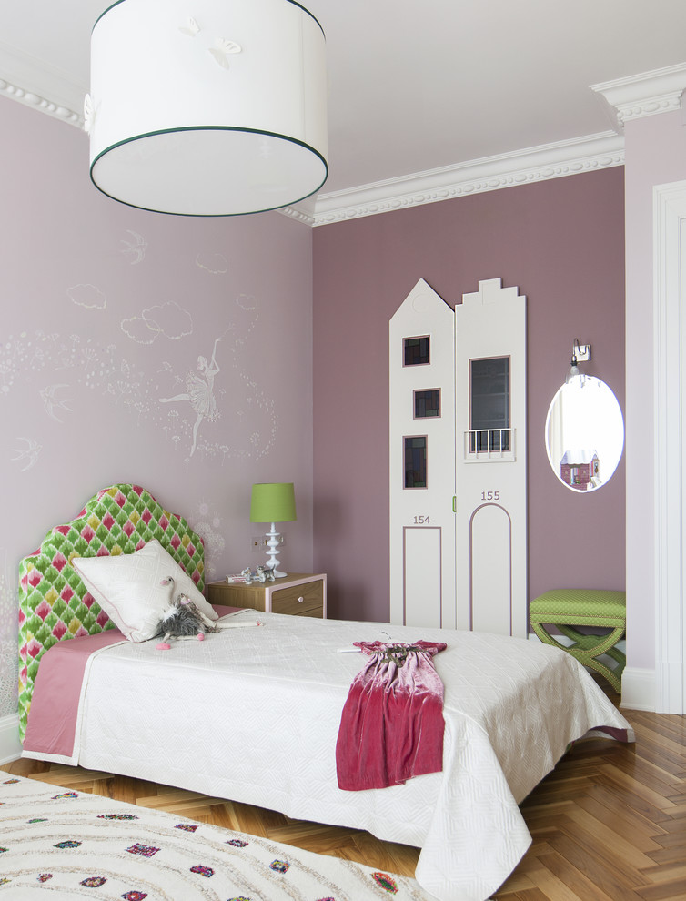 Inredning av ett klassiskt stort flickrum kombinerat med sovrum och för 4-10-åringar, med rosa väggar och mellanmörkt trägolv
