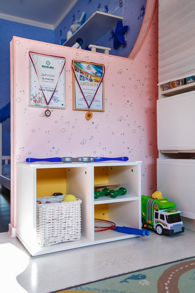Photo of a medium sized contemporary toddler’s room for boys in Other with pink walls, laminate floors and white floors.