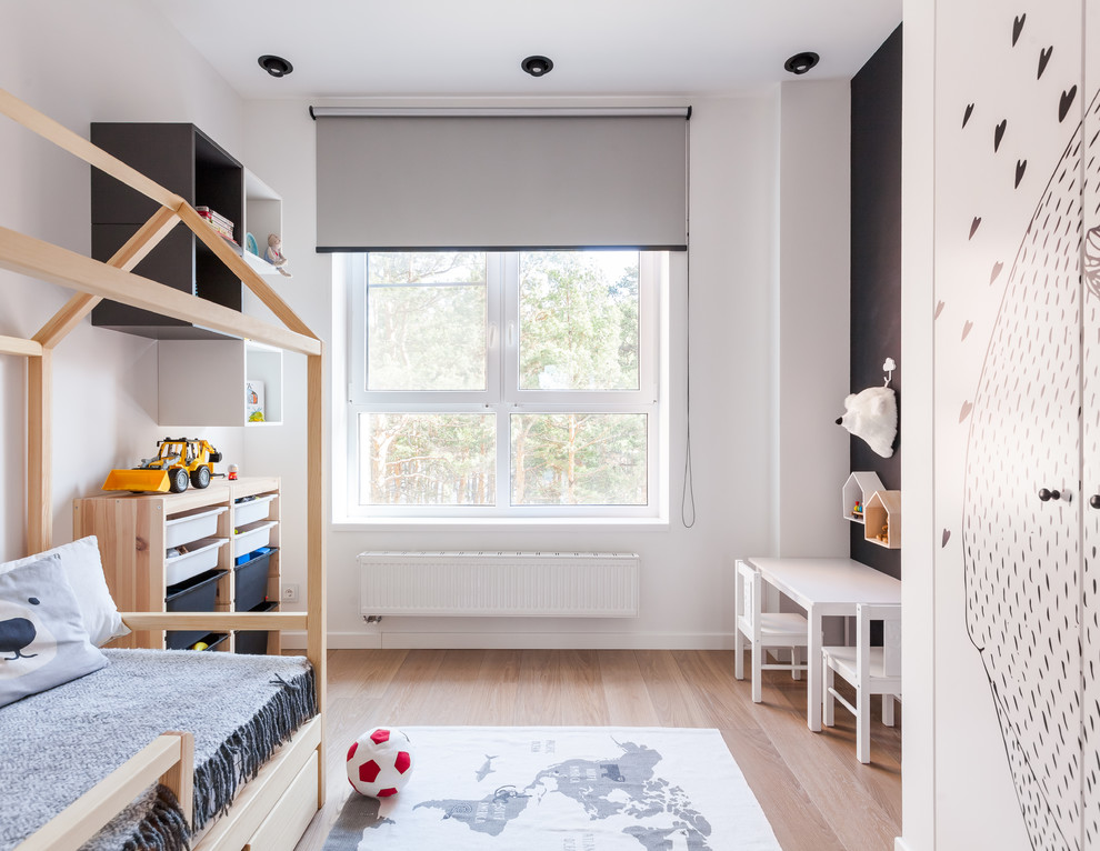 Modelo de dormitorio infantil de 4 a 10 años contemporáneo con paredes blancas, suelo de madera en tonos medios y suelo marrón