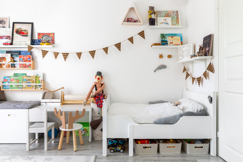 На фото: нейтральная детская в скандинавском стиле с спальным местом, белыми стенами и серым полом для ребенка от 1 до 3 лет