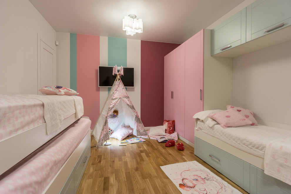 Mittelgroßes Modernes Mädchenzimmer mit braunem Holzboden, beigem Boden, Spielecke und bunten Wänden in Moskau