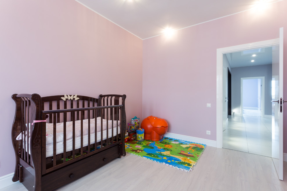 Inredning av ett klassiskt litet barnrum kombinerat med lekrum, med rosa väggar, laminatgolv och beiget golv