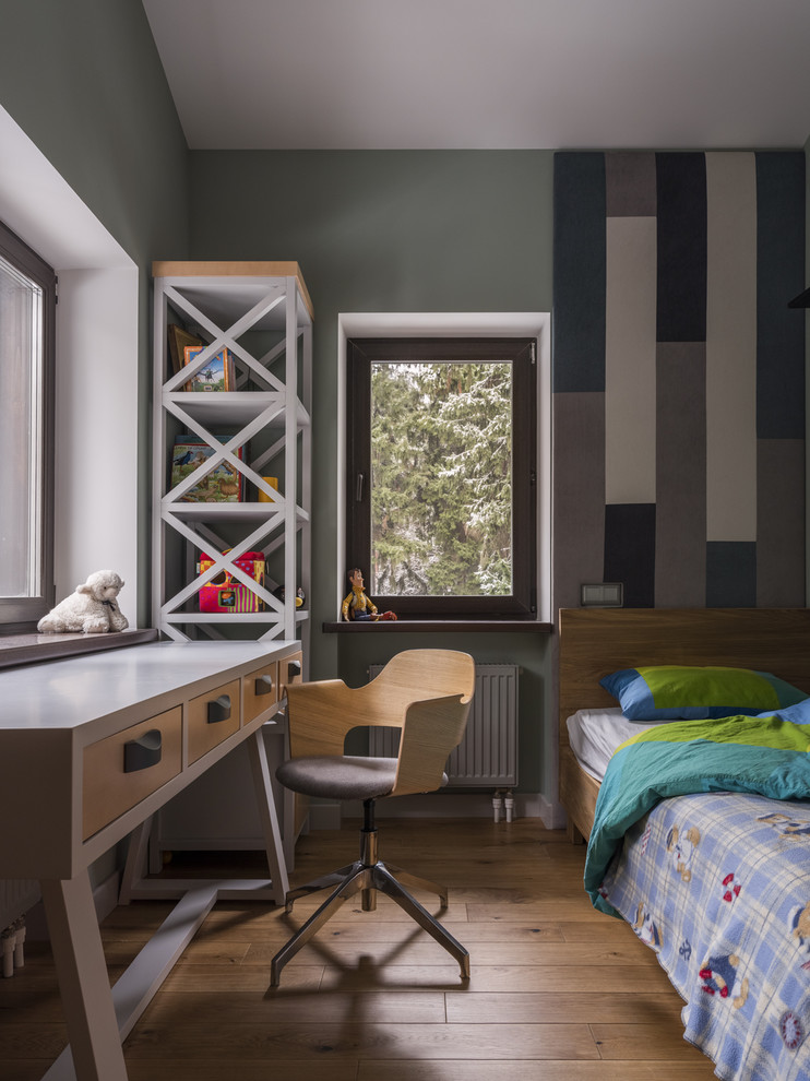 Aménagement d'une chambre de garçon de 4 à 10 ans contemporaine de taille moyenne avec un bureau, un mur gris, un sol en bois brun et un sol marron.