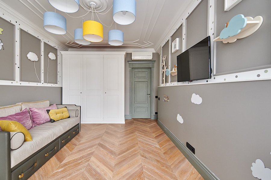 Immagine di una cameretta per bambini da 1 a 3 anni scandinava di medie dimensioni con pareti grigie, parquet chiaro e pavimento beige