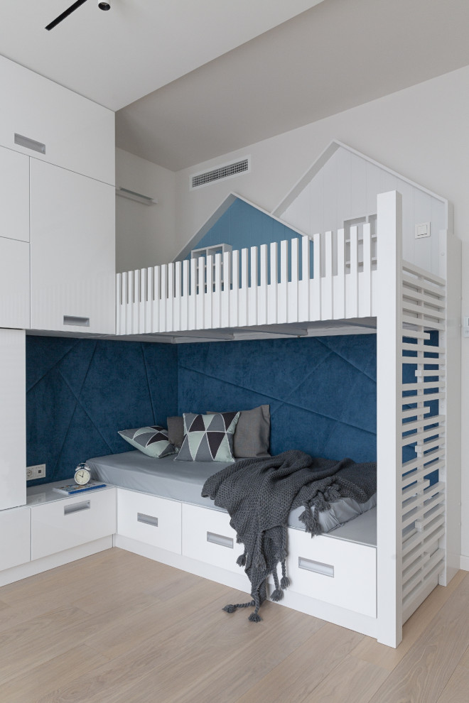 Exempel på ett modernt könsneutralt barnrum kombinerat med sovrum och för 4-10-åringar, med vita väggar, ljust trägolv och beiget golv