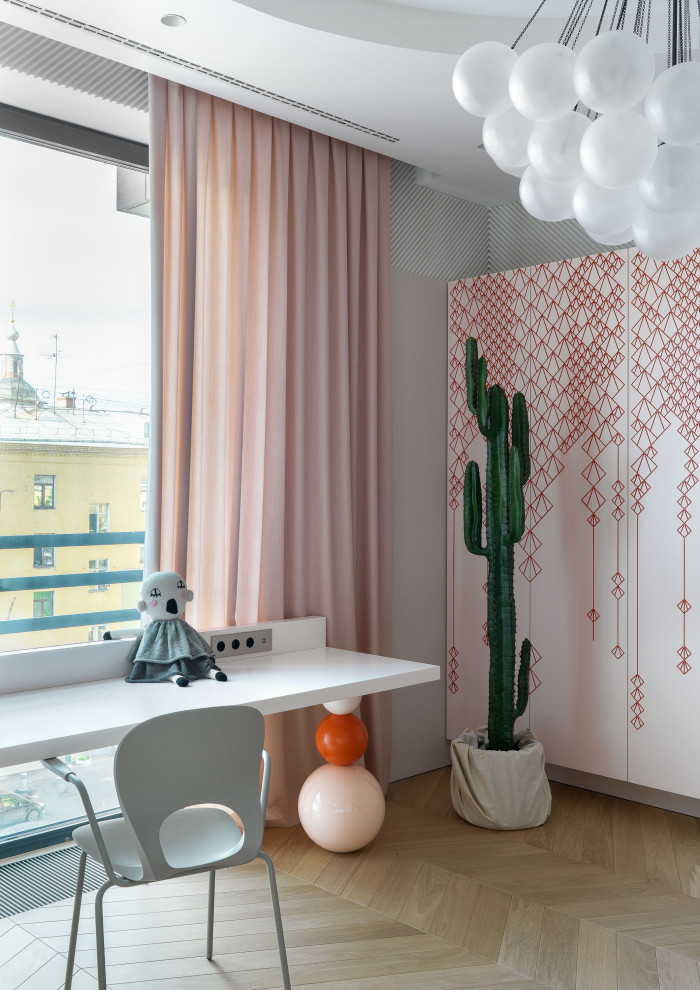 Esempio di una grande cameretta per bambini design con pareti rosa, parquet chiaro e pavimento beige