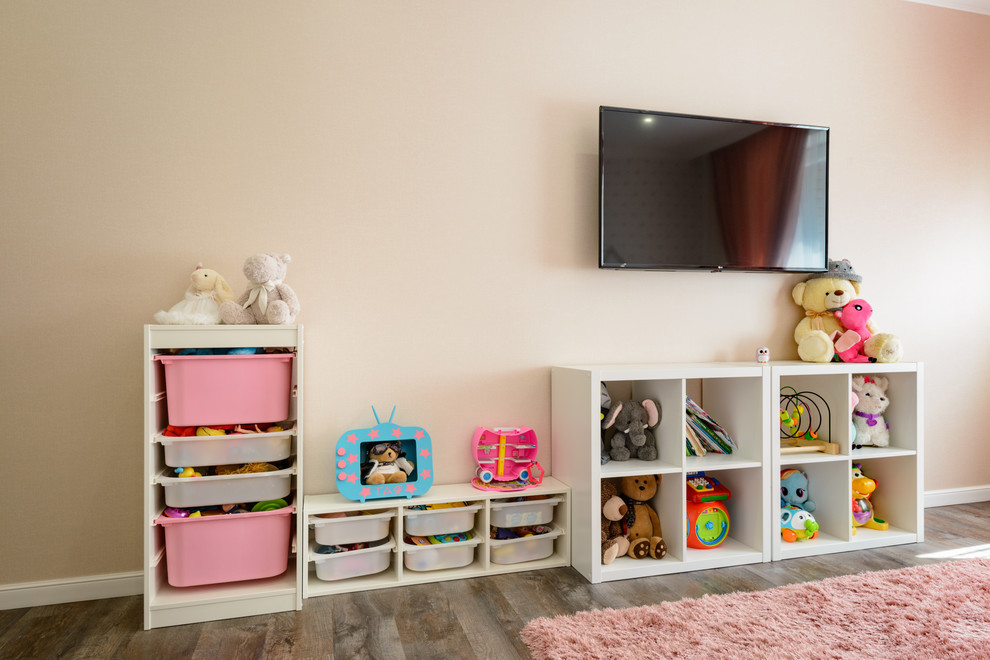 На фото: детская среднего размера в современном стиле с розовыми стенами, полом из винила и коричневым полом для ребенка от 4 до 10 лет, девочки