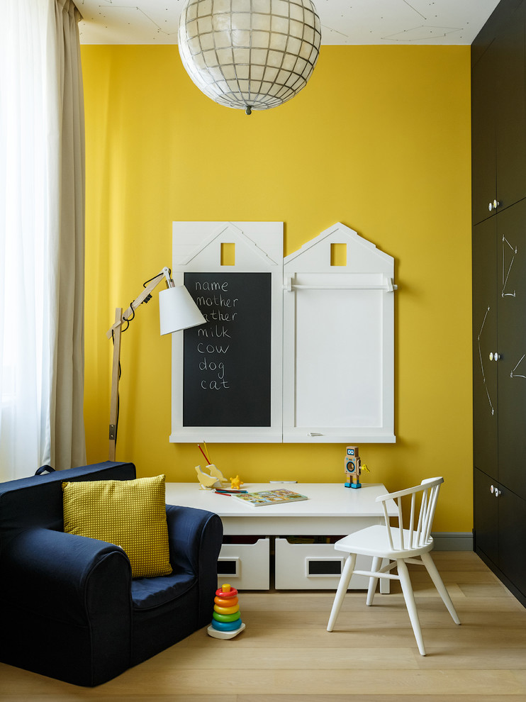 Réalisation d'une petite chambre d'enfant de 1 à 3 ans design avec un mur jaune et parquet clair.