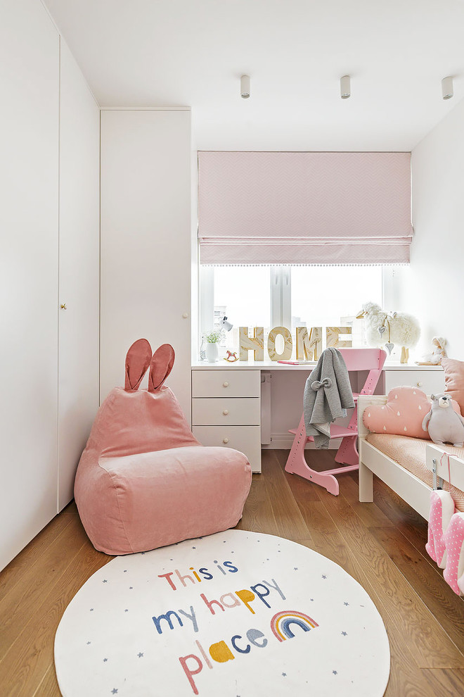 Réalisation d'une chambre d'enfant de 1 à 3 ans design avec un mur blanc et parquet clair.