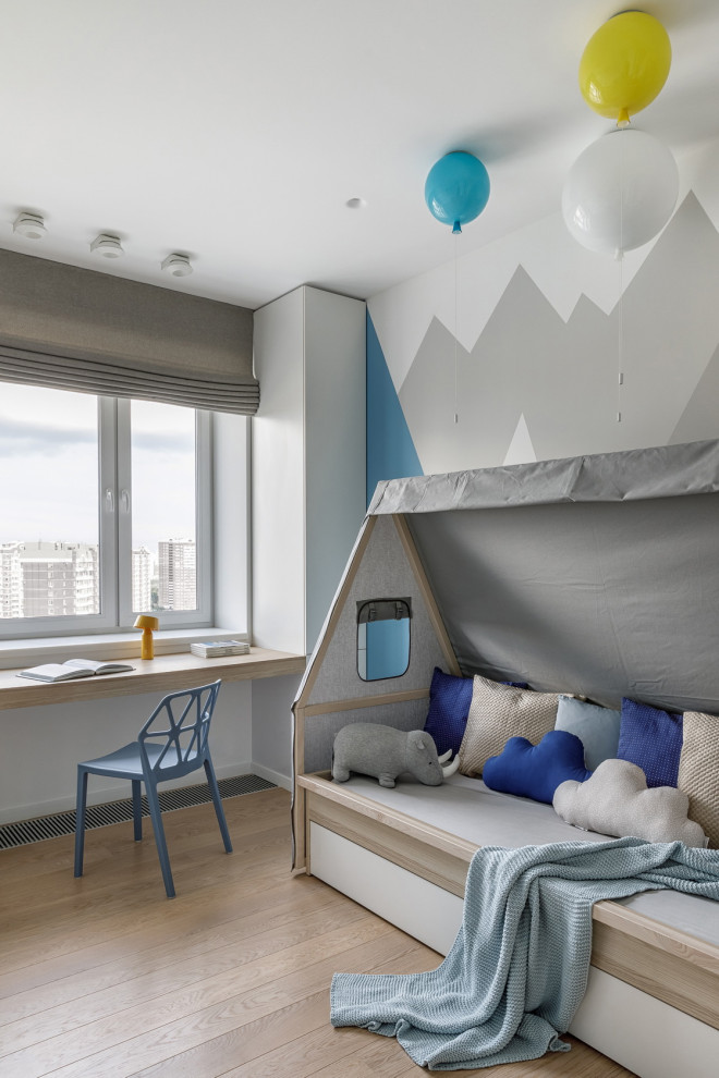 Aménagement d'une chambre d'enfant de 1 à 3 ans scandinave de taille moyenne avec un mur multicolore, parquet clair et un sol beige.