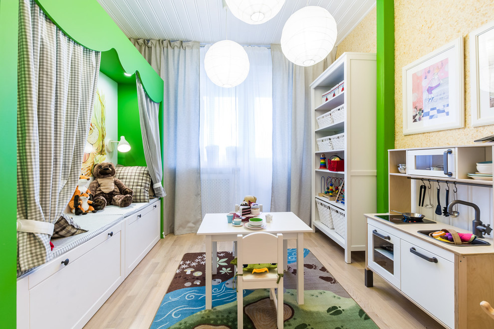 Modern inredning av ett könsneutralt småbarnsrum kombinerat med lekrum, med gula väggar och ljust trägolv