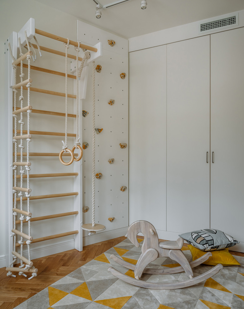 Exemple d'une chambre d'enfant de 1 à 3 ans scandinave de taille moyenne avec un mur blanc, un sol en bois brun et un sol marron.