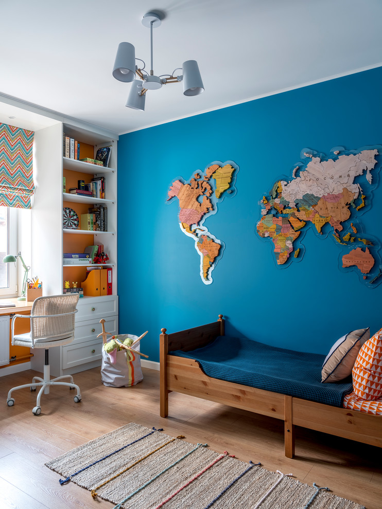 Diseño de habitación de niño de 4 a 10 años marinera de tamaño medio con paredes azules, suelo de madera en tonos medios y suelo beige