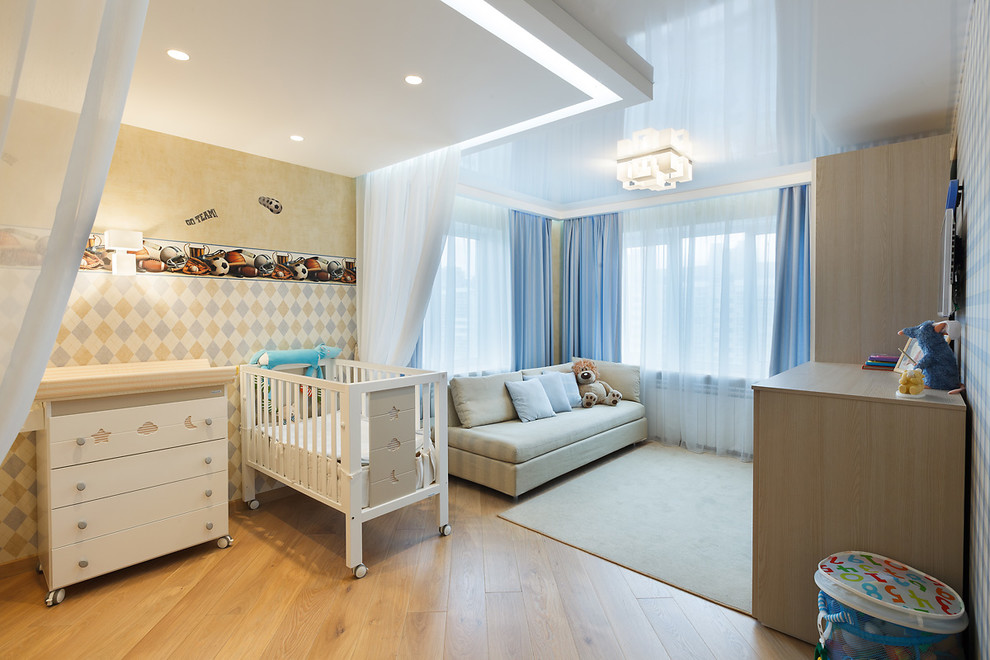 Diseño de dormitorio infantil de 1 a 3 años actual de tamaño medio con paredes multicolor, suelo de madera clara y suelo beige