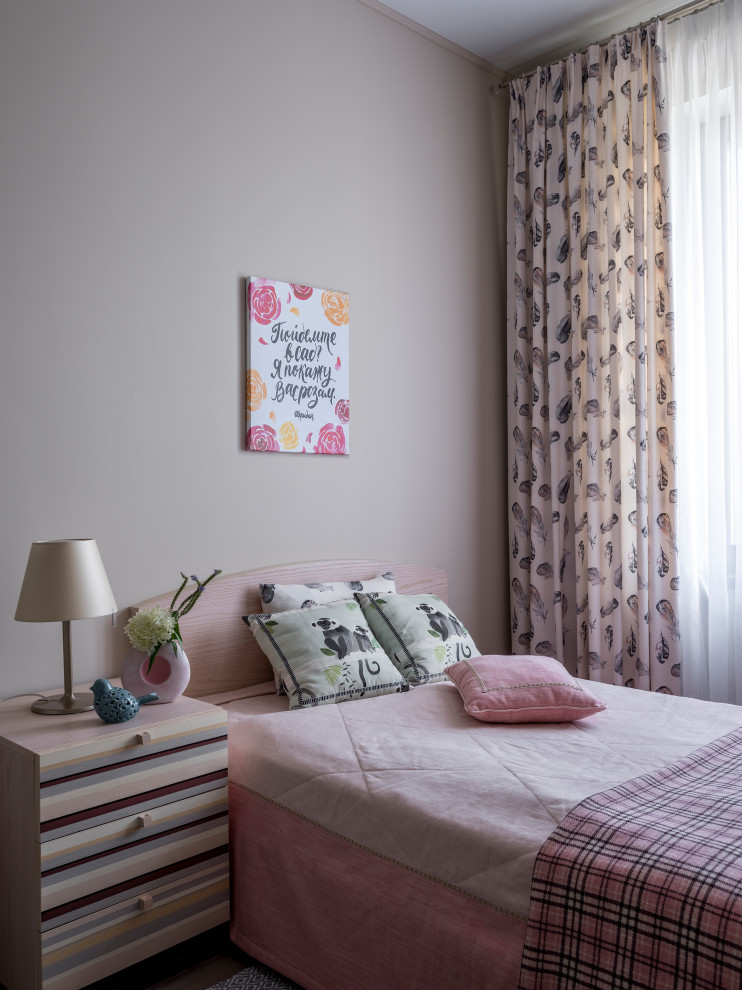 Foto på ett litet funkis barnrum kombinerat med sovrum, med beige väggar, mellanmörkt trägolv och beiget golv