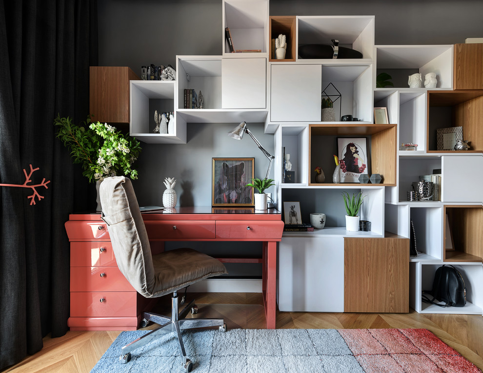 Réalisation d'une chambre neutre design avec un mur gris, un sol en bois brun, un bureau et un sol marron.