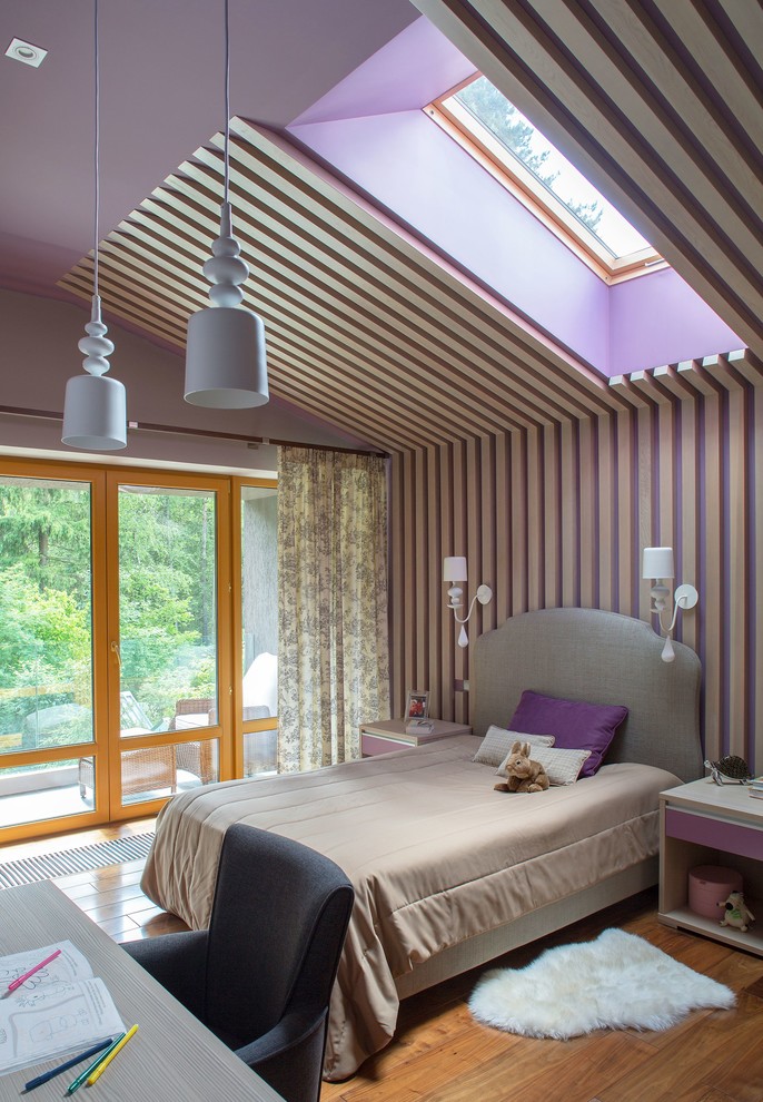 Cette photo montre une chambre d'enfant de 4 à 10 ans tendance de taille moyenne avec un mur violet, un sol marron et un sol en bois brun.