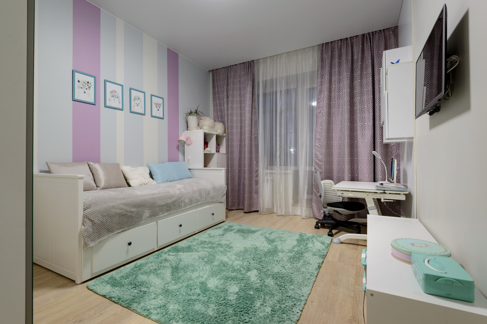 This is an example of a large contemporary children’s room for girls in Novosibirsk with white walls, laminate floors and beige floors.