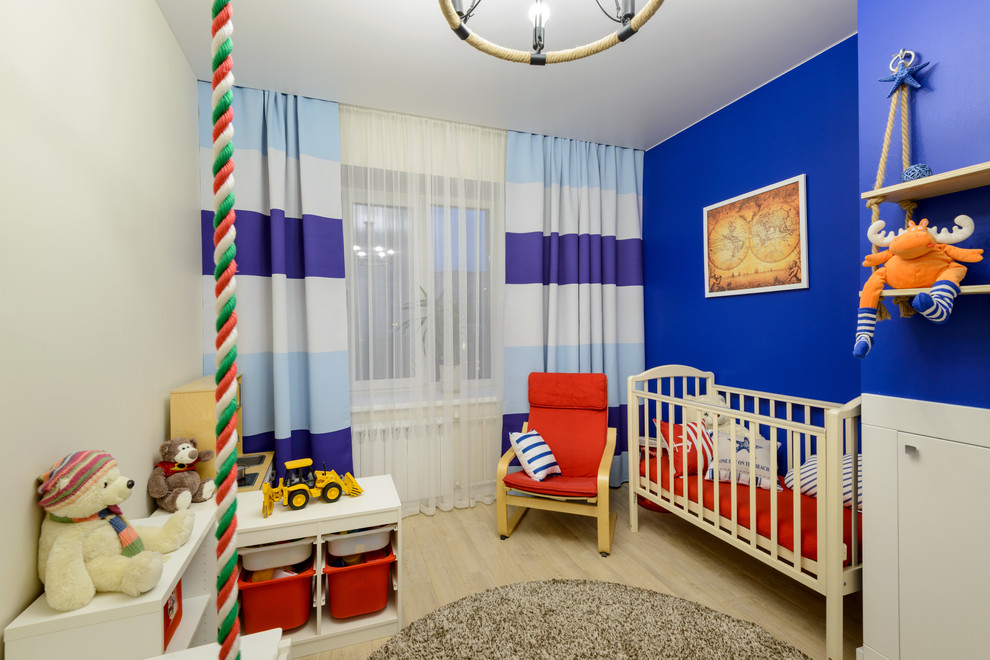 На фото: детская среднего размера в современном стиле с синими стенами, полом из ламината и бежевым полом для мальчика