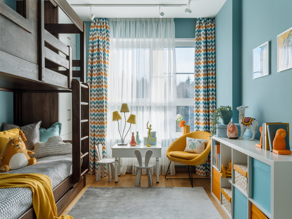 Imagen de dormitorio infantil contemporáneo con paredes azules, suelo de madera en tonos medios y suelo marrón