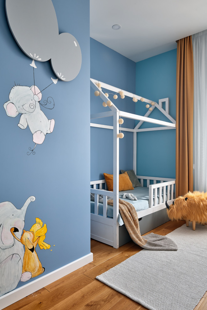 Ispirazione per una cameretta per bambini design con pareti blu, pavimento in legno massello medio e pavimento marrone