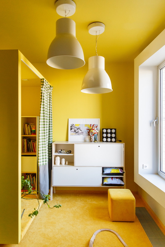 Modern inredning av ett barnrum, med gula väggar, heltäckningsmatta och gult golv