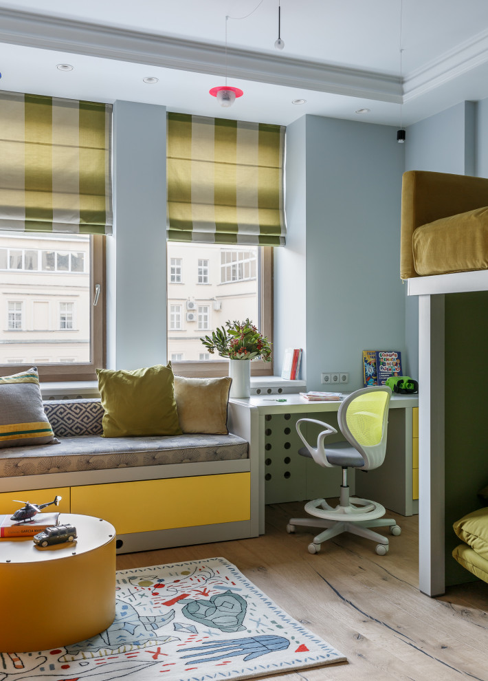 Idée de décoration pour une chambre d'enfant de 4 à 10 ans design de taille moyenne avec un mur bleu, parquet clair et un sol beige.