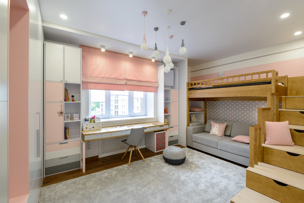 На фото: детская в современном стиле с розовыми стенами, паркетным полом среднего тона, коричневым полом и спальным местом для девочки с