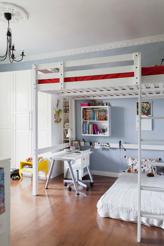 Ejemplo de habitación infantil unisex de 4 a 10 años escandinava con paredes azules y suelo de madera en tonos medios