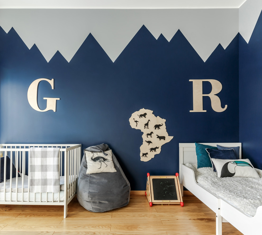 На фото: нейтральная детская в скандинавском стиле с спальным местом, синими стенами, паркетным полом среднего тона и коричневым полом для ребенка от 4 до 10 лет