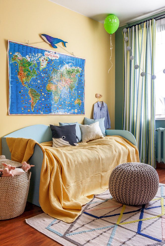 Medium sized contemporary gender neutral children’s room in Other with yellow walls, laminate floors and orange floors.