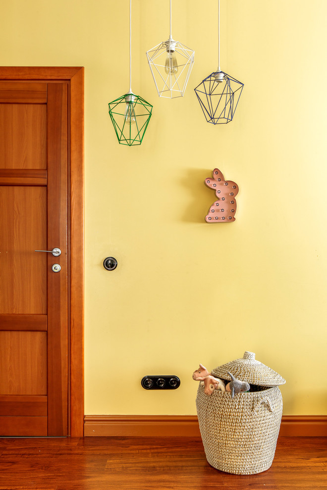 Idéer för ett mellanstort modernt könsneutralt barnrum för 4-10-åringar, med gula väggar, laminatgolv och orange golv