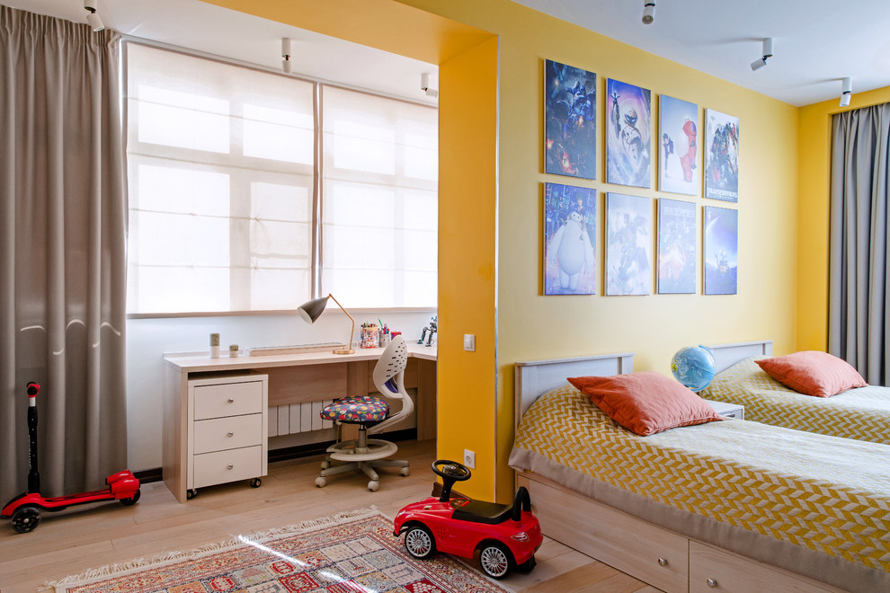 Diseño de dormitorio infantil actual con paredes amarillas, suelo de madera clara y suelo beige