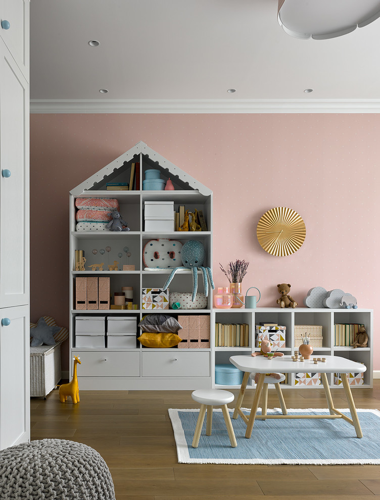 Inspiration för ett stort funkis barnrum kombinerat med lekrum, med rosa väggar och mellanmörkt trägolv