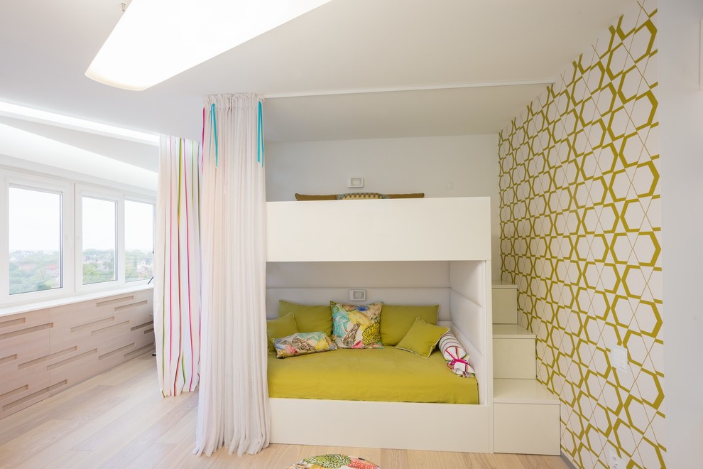 Modern inredning av ett mellanstort barnrum kombinerat med sovrum, med flerfärgade väggar och ljust trägolv