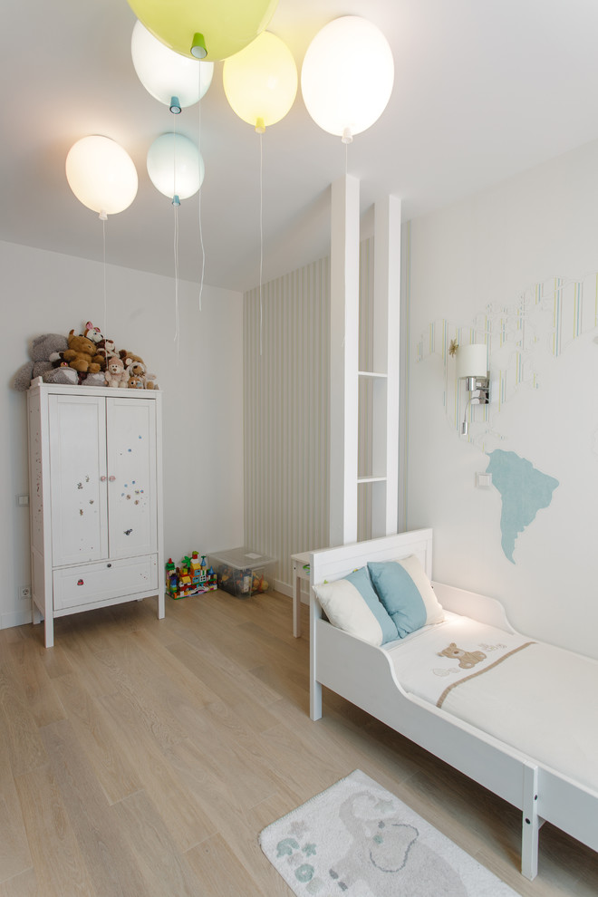 Exemple d'une petite chambre d'enfant de 1 à 3 ans éclectique avec un mur blanc, un sol en bois brun et un sol beige.