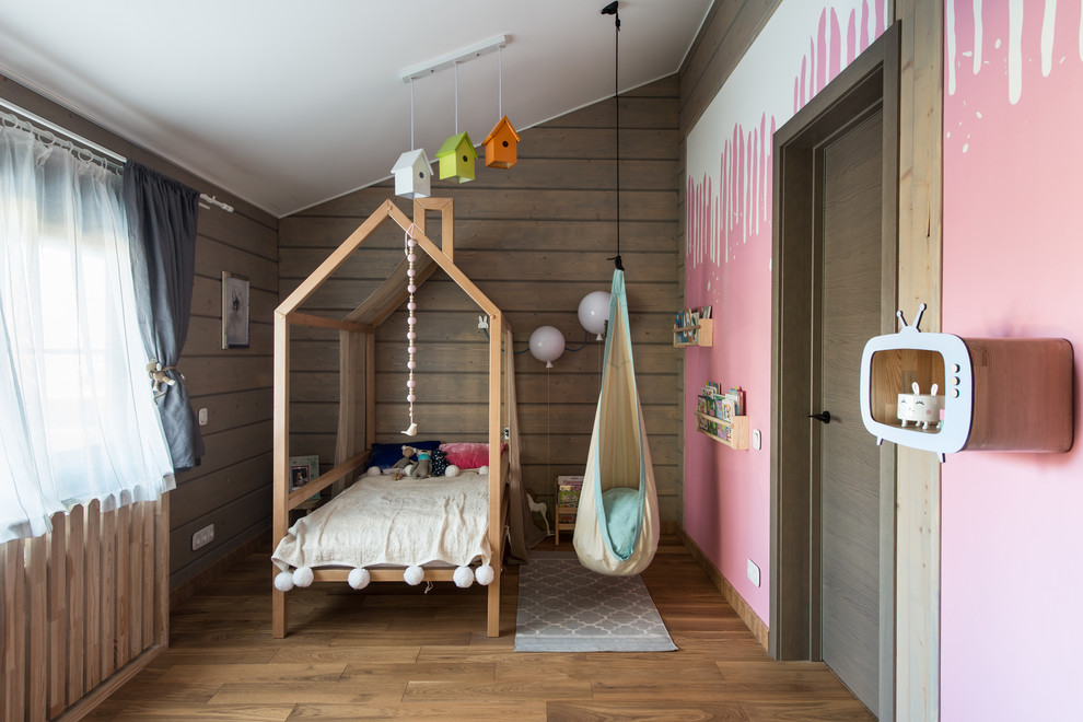 Пример оригинального дизайна: детская в современном стиле с спальным местом, розовыми стенами, паркетным полом среднего тона и коричневым полом для ребенка от 4 до 10 лет, девочки