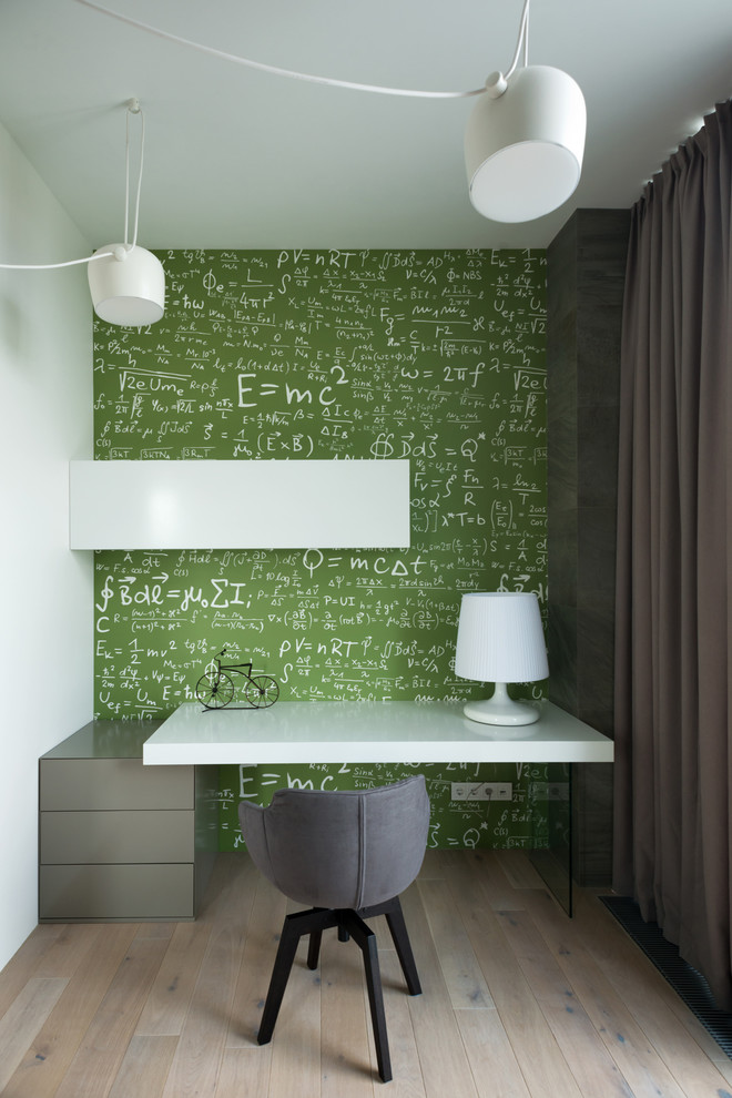 Photo of a medium sized contemporary gender neutral kids' study space in Moscow with light hardwood flooring and green walls.