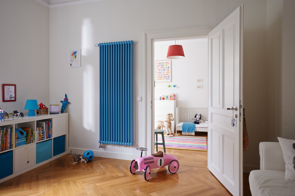 This is an example of a contemporary gender neutral kids' bedroom in Moscow with white walls, medium hardwood flooring and brown floors.