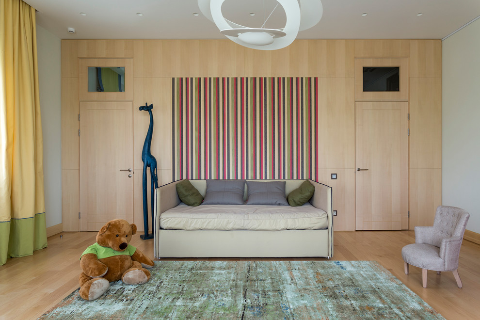 Ejemplo de dormitorio infantil de 4 a 10 años actual de tamaño medio con paredes blancas y suelo de madera clara