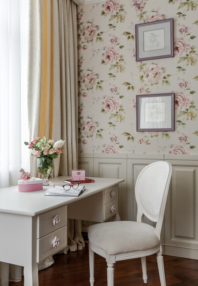 This is an example of a traditional kids' study space for girls in Moscow with pink walls, dark hardwood flooring and brown floors.