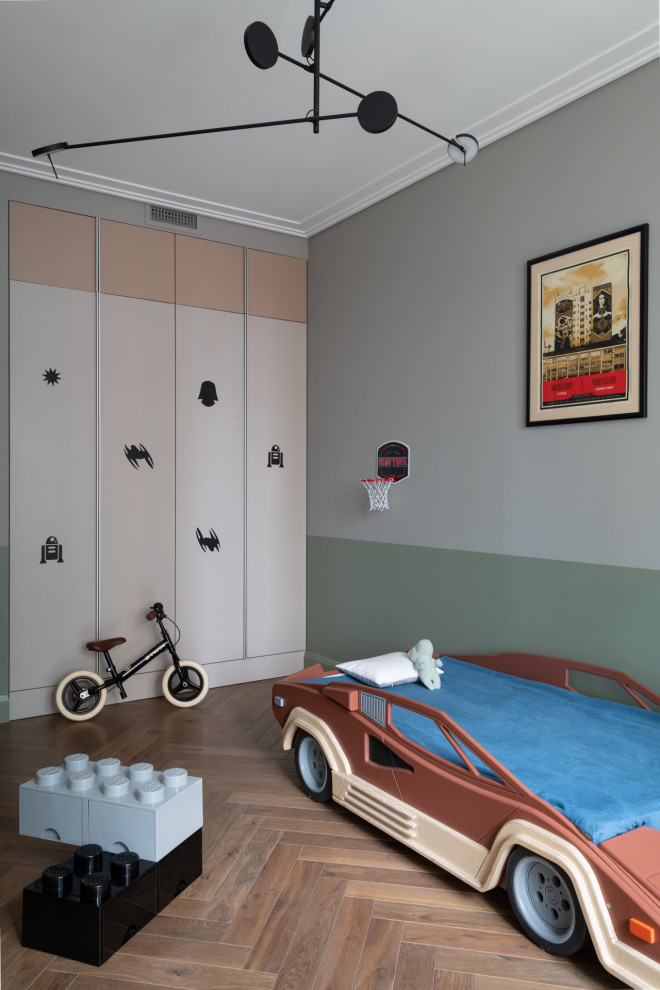 This is an example of a contemporary kids' bedroom for boys in Other with multi-coloured walls, medium hardwood flooring and brown floors.
